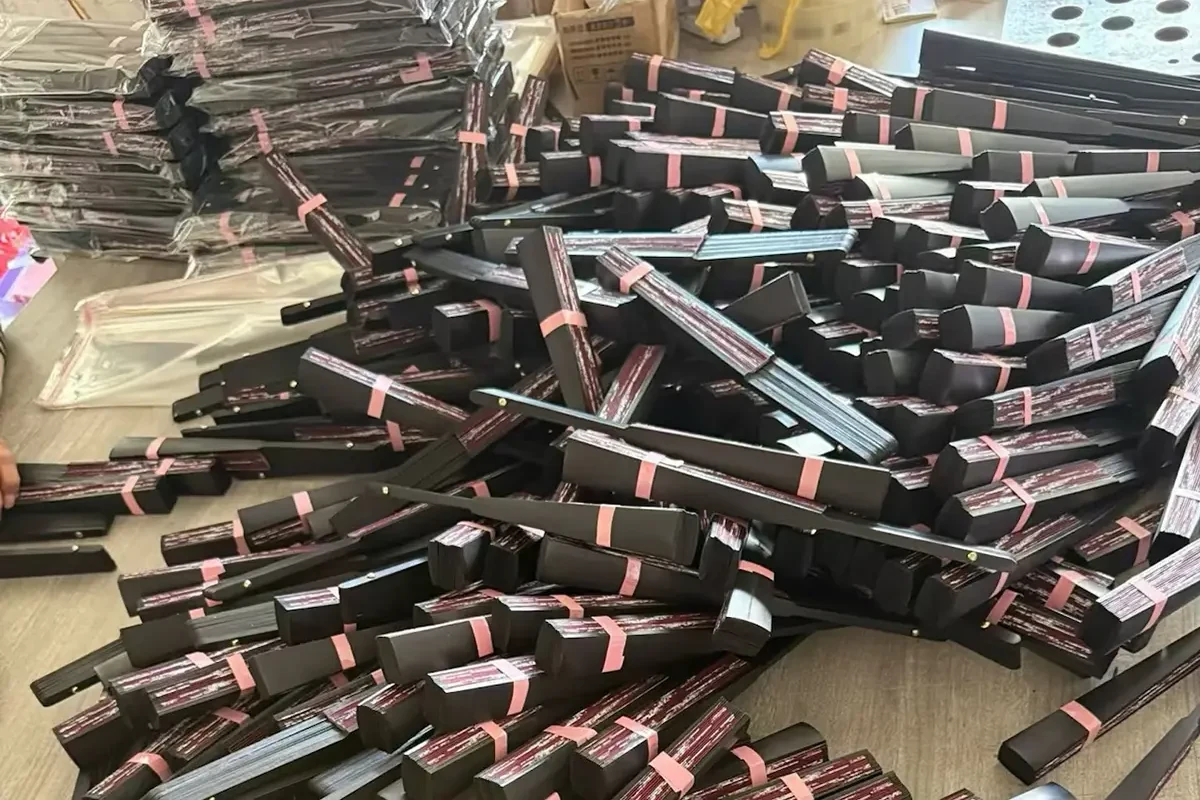 Folded fans held with pink bands beside stacks of clear-wrapped fans.