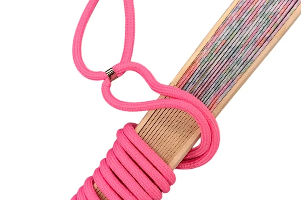 Folded fan wrapped with a bright pink carrying cord.