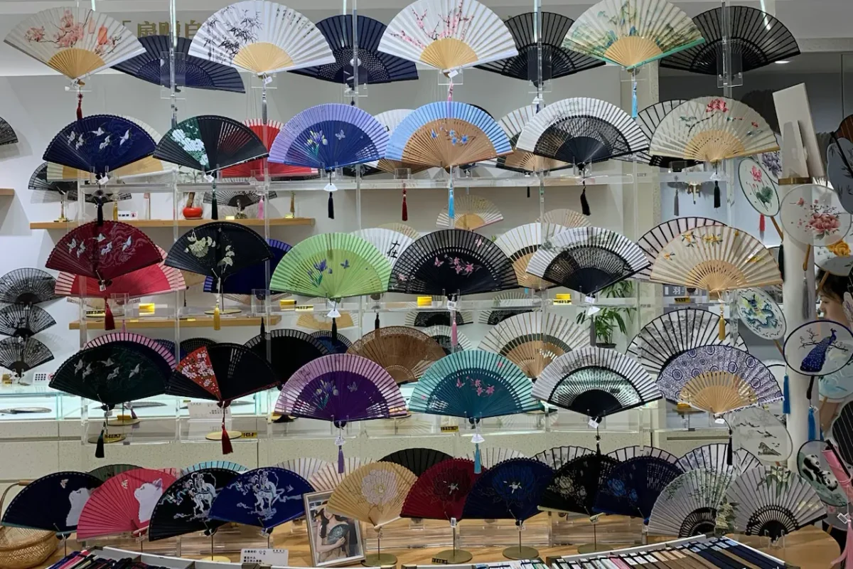 Rows of open folding fans in varied colors and patterns on display.