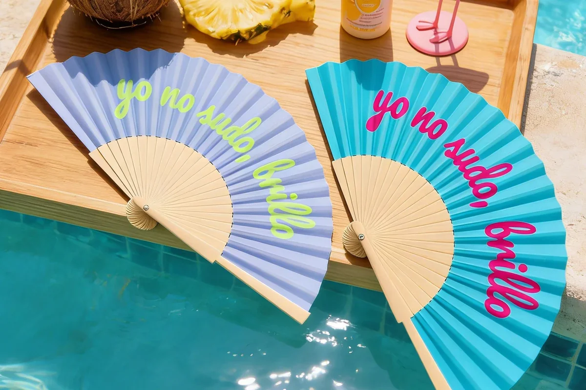 Two colorful folding fans arranged beside a pool.