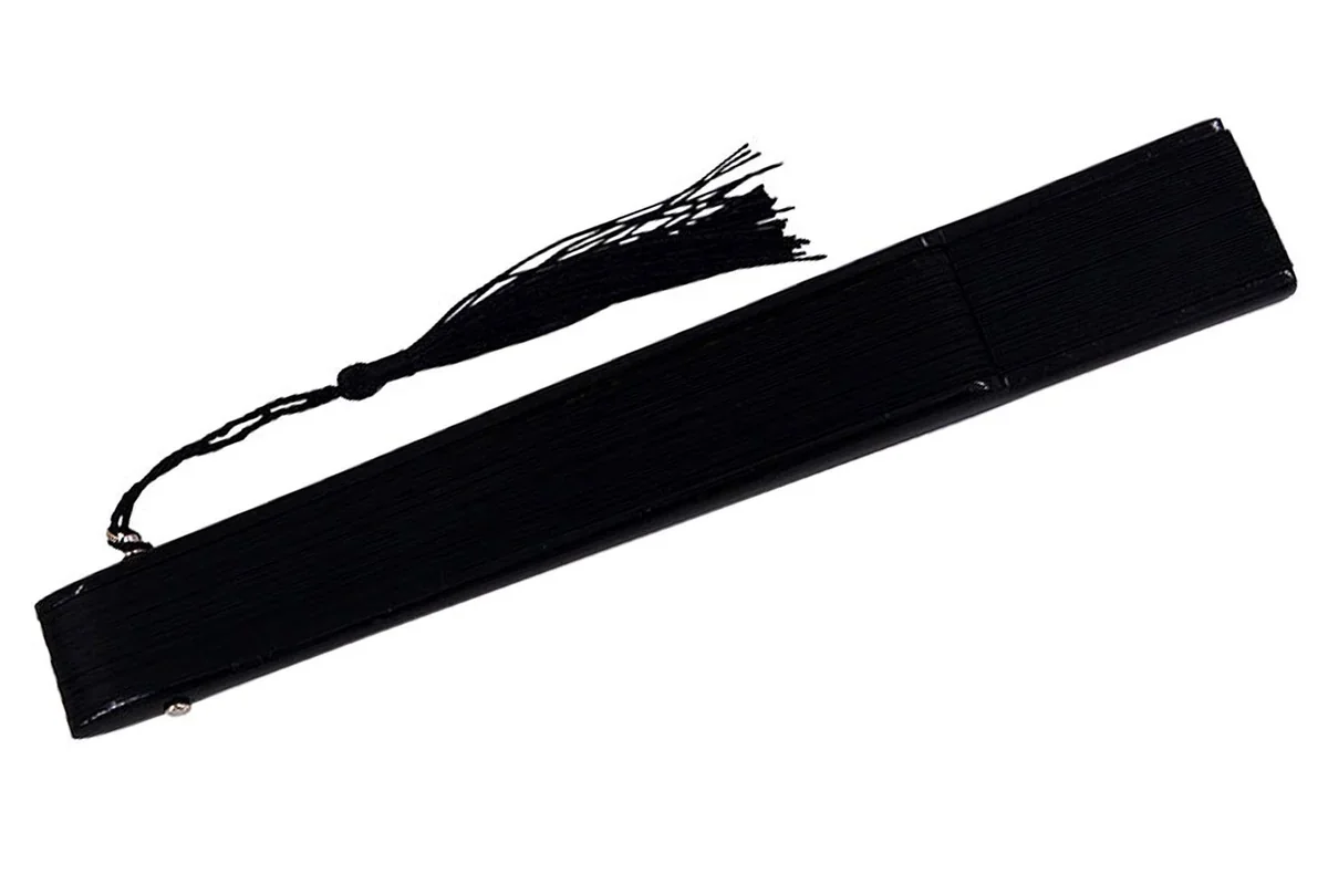 Closed black folding fan with a matching tassel.
