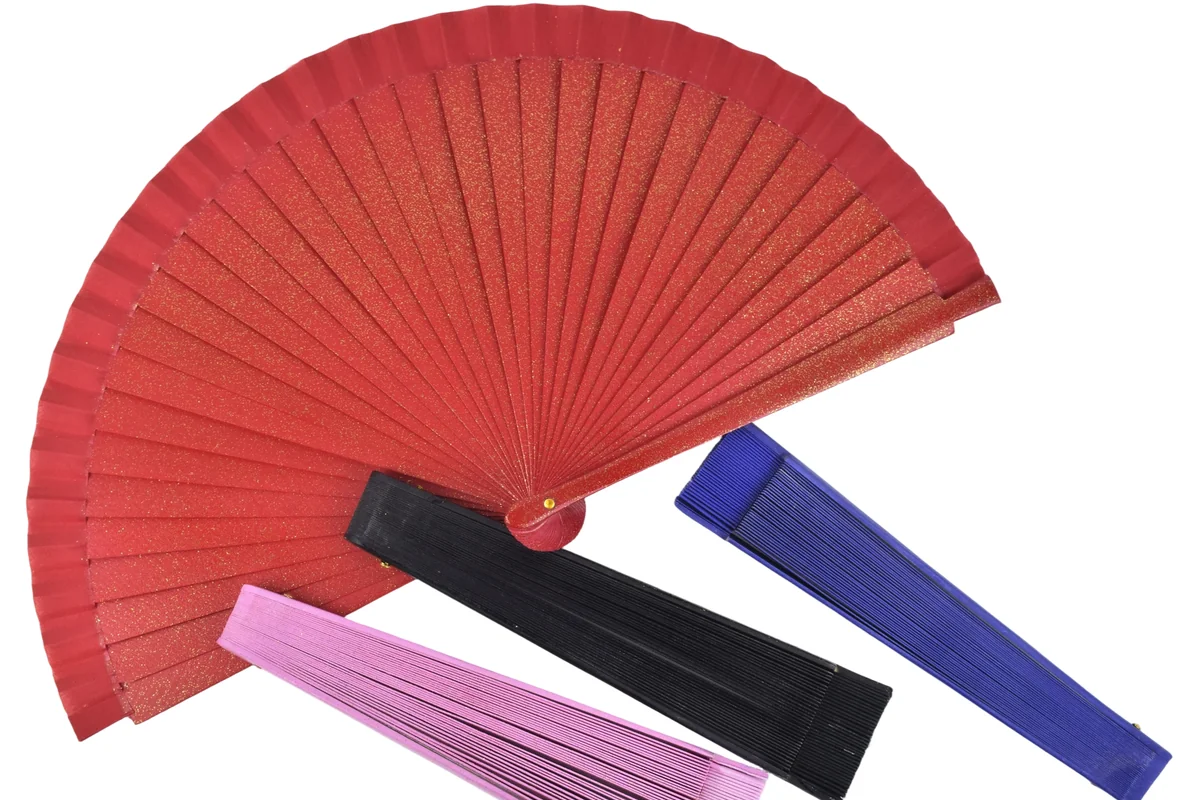 Red open folding fan beside folded fans in contrasting colors.