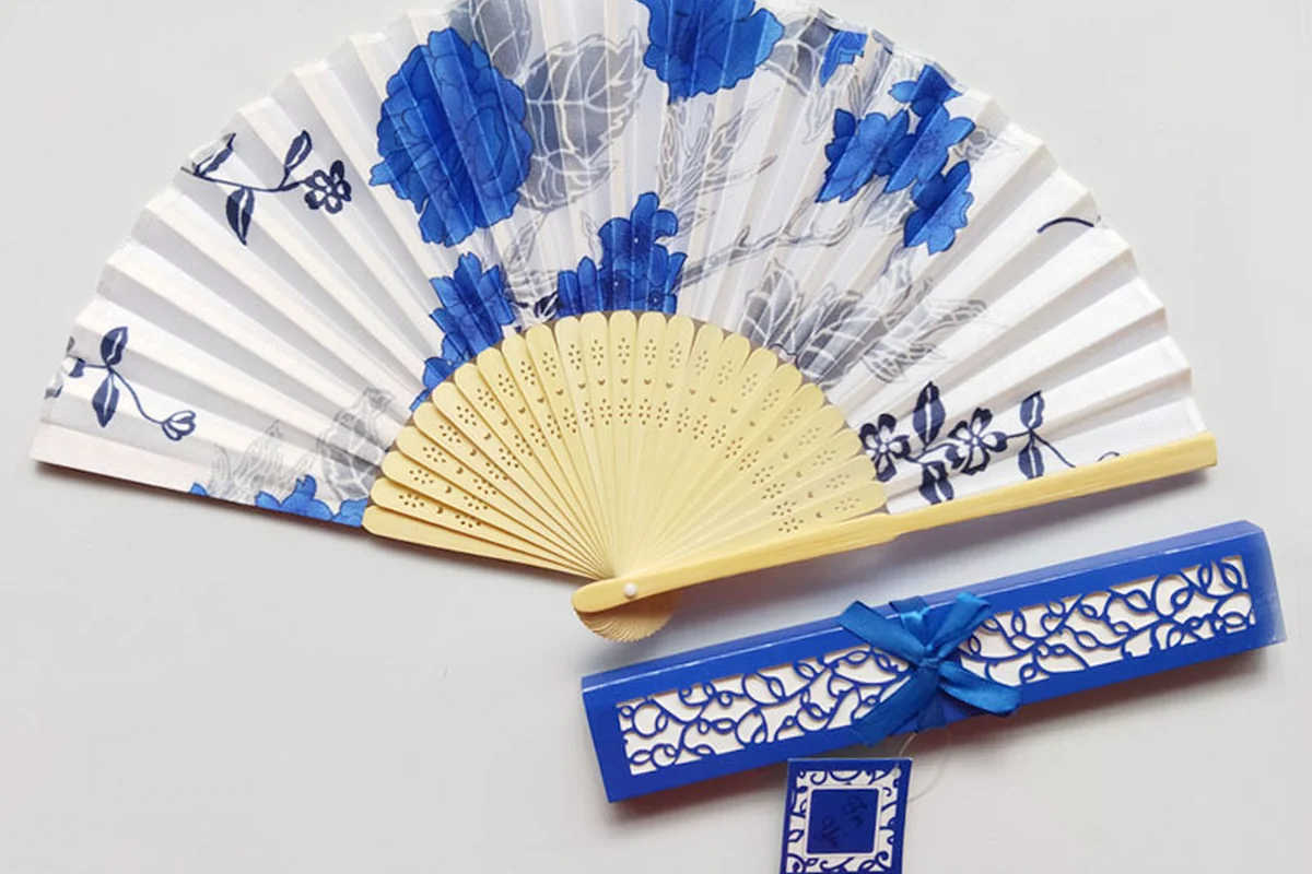 White folding fan with blue flowers and a matching blue gift box.