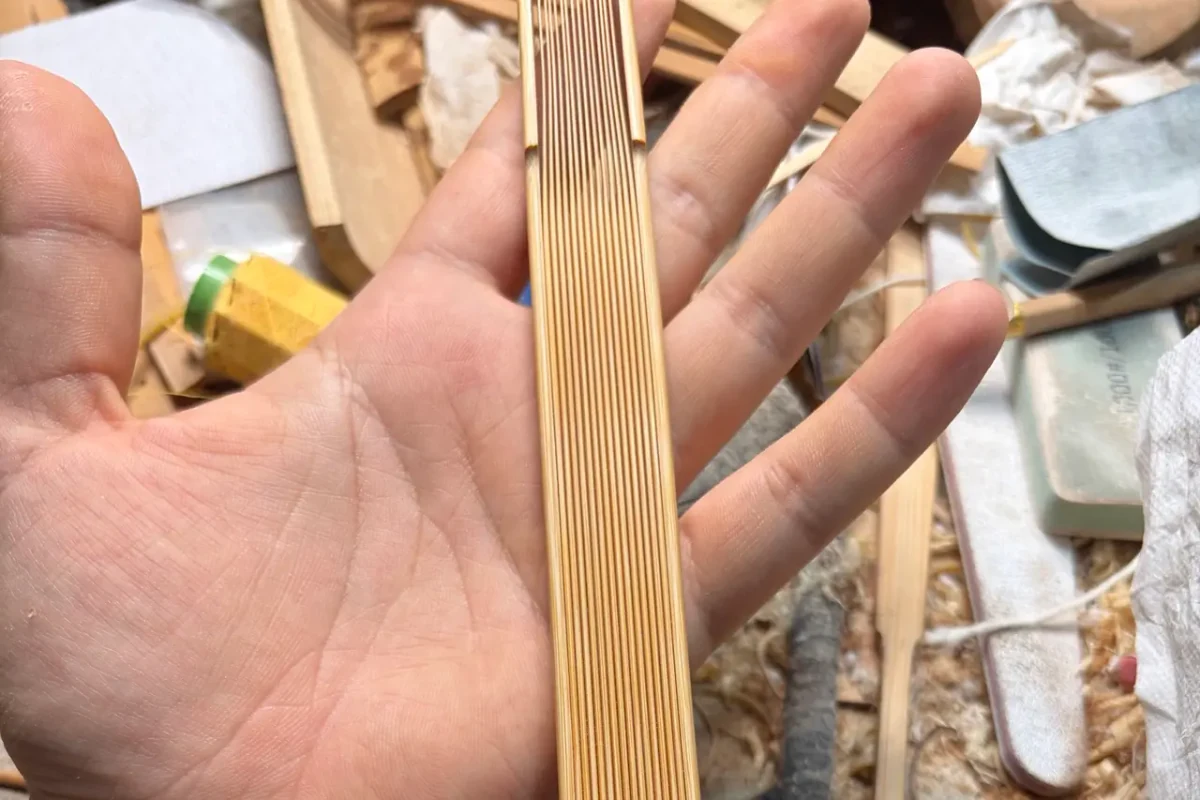 Close-up of the surfaces and edges of stacked natural-colored fan ribs.