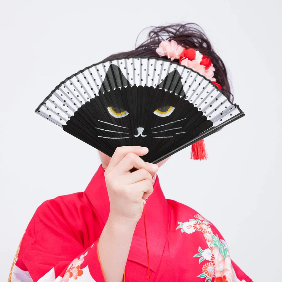 Person holding an open black cat illustration folding fan