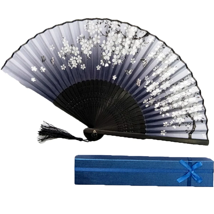 Dark gradient folding fan with white blossoms, a black frame and tassel