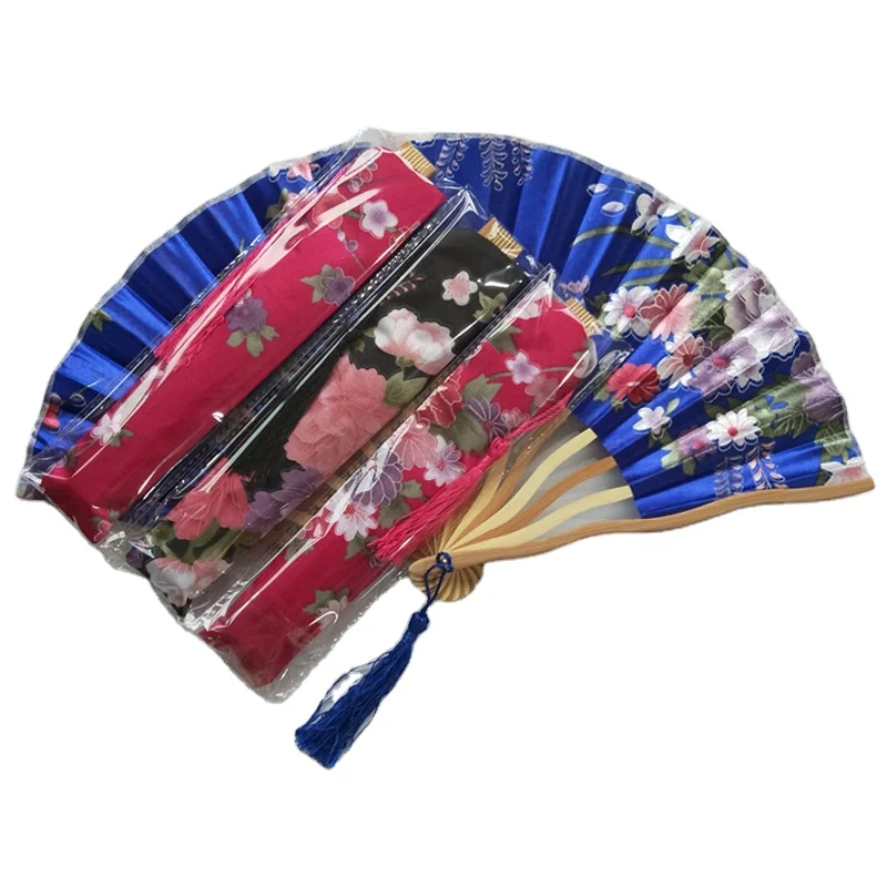 Packaged floral folding fans beside an open blue floral fan with a tassel