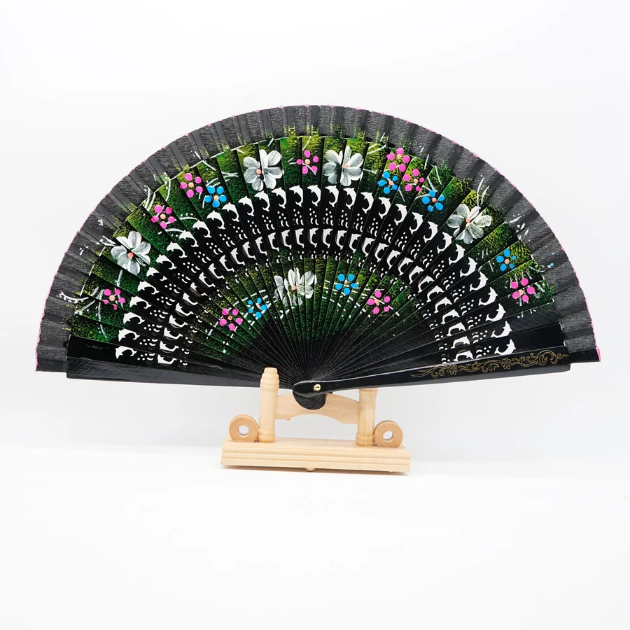Black floral folding fan with decorative openings displayed on a stand