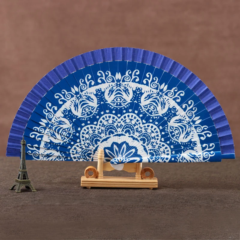 Blue folding fan with a large white mandala pattern on a stand
