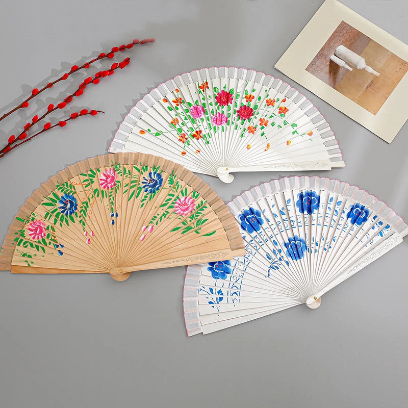 Natural tone botanical fan displayed with two white floral fan variants