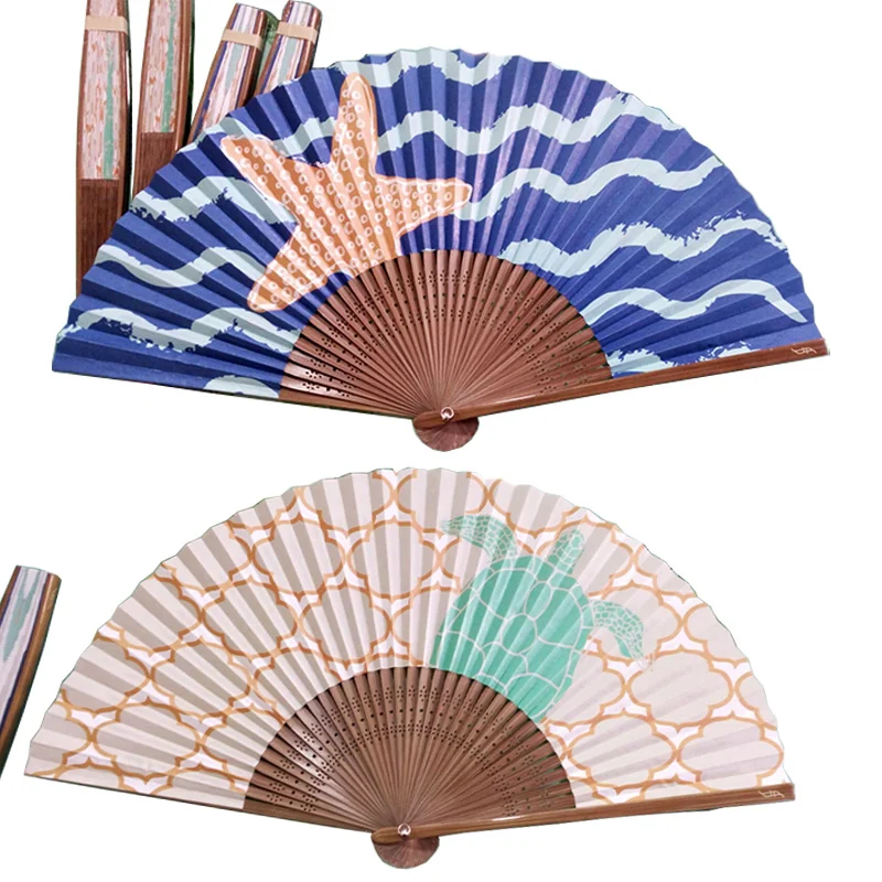 Two patterned souvenir folding fans with blue wave and pale decorative artwork