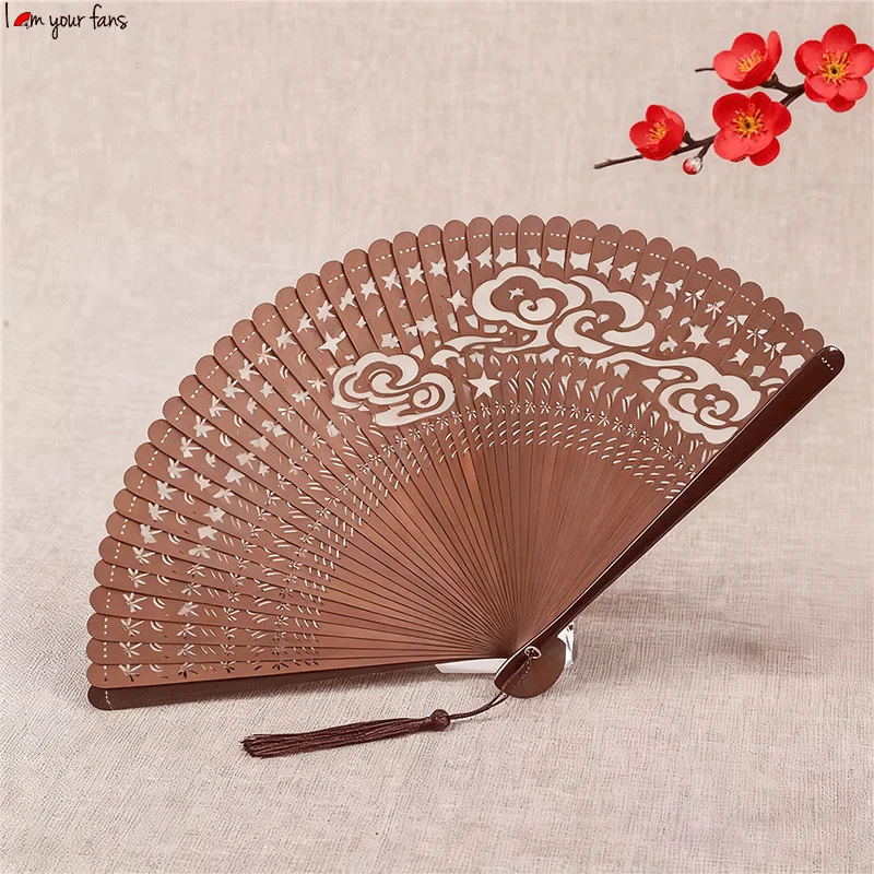 Brown pierced folding fan with an ornamental motif and matching tassel