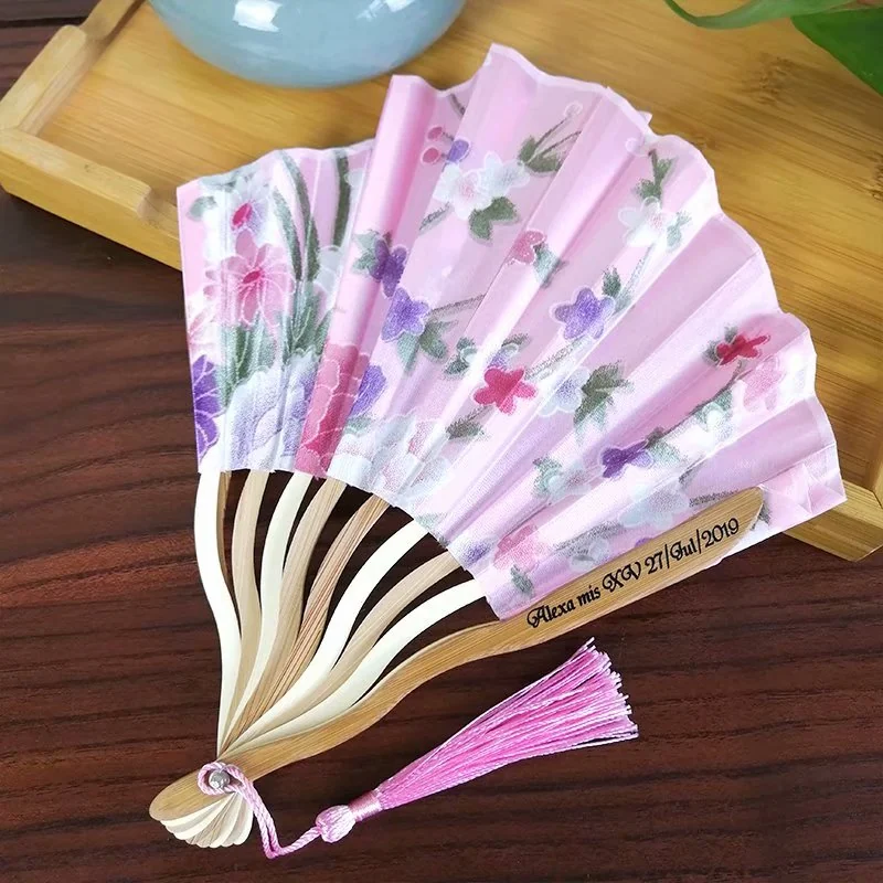 Partly open pink floral fan with curved ribs and a pink tassel