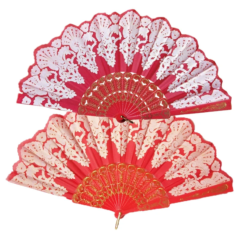 Two red folding fans with cream ornamental patterns and scalloped edges