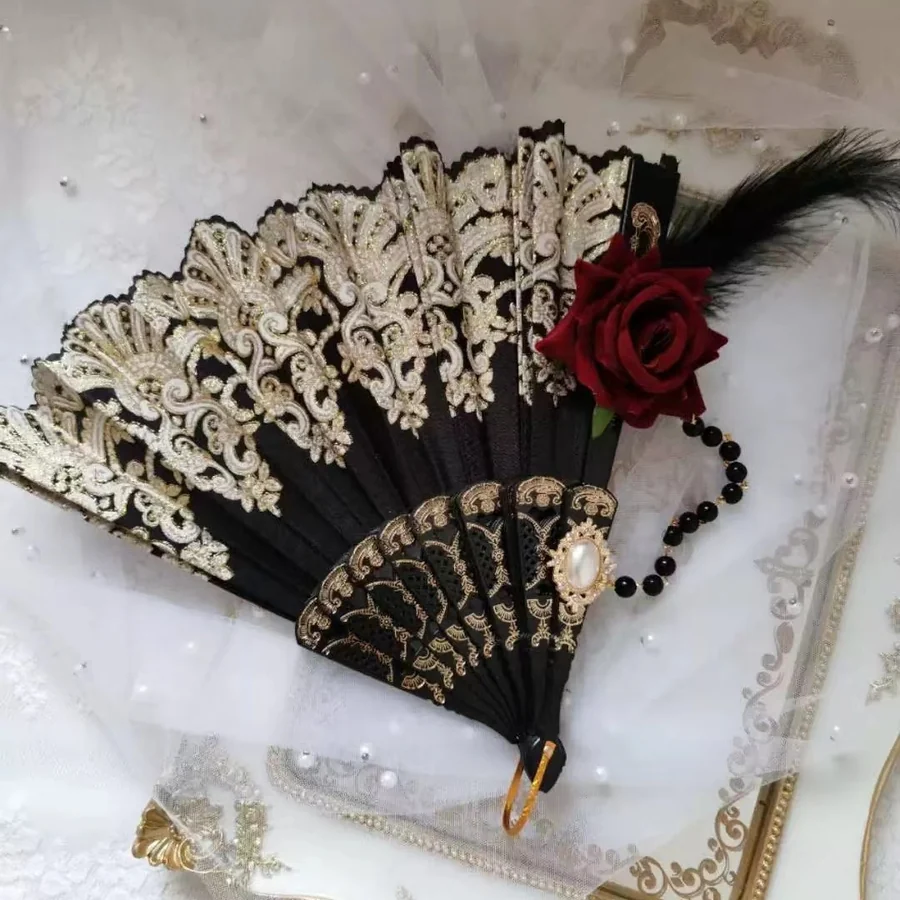 Dark ornamental folding fan styled with a red rose and tassel