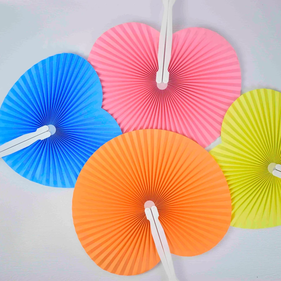 Colorful round pleated fans in pink, orange, blue and yellow with white handles
