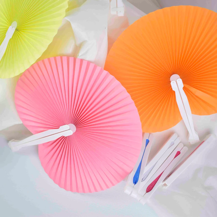 Open pink and orange pleated fans beside folded fans with white handles