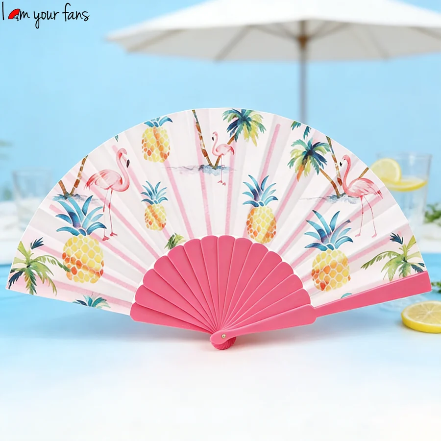 Pink framed tropical print folding fan displayed beside a summer parasol