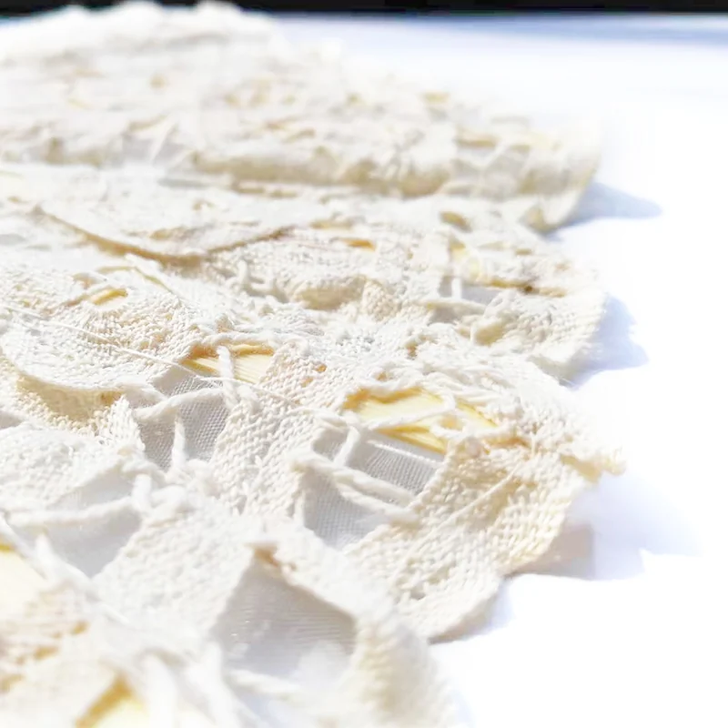 Close view of white floral lace and the scalloped fan edge