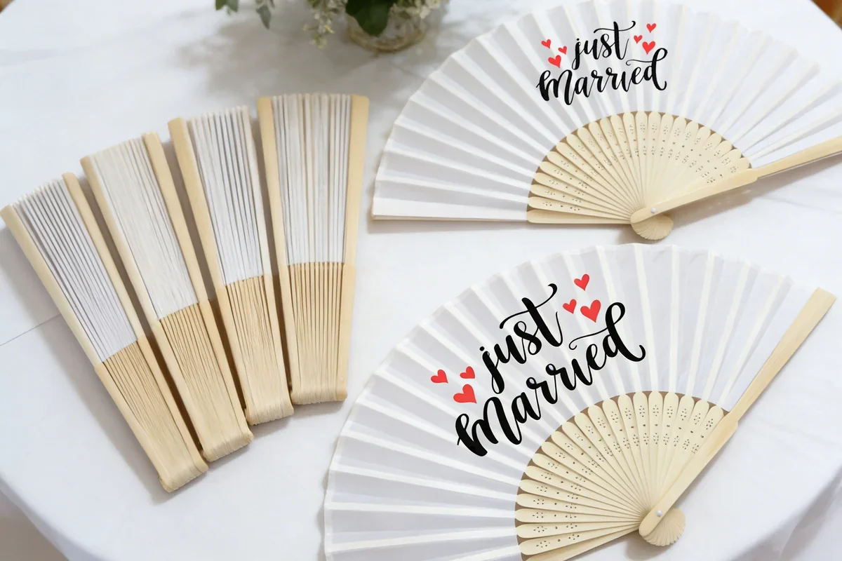 White wedding fans and folded fans on a table.
