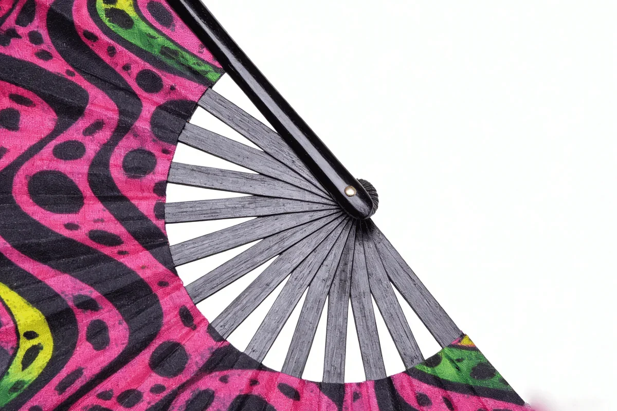 Close view of a patterned fan leaf, black ribs and pivot.